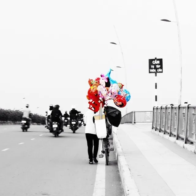 Cô bán hàng rong đi trên phố với những chiếc bóng bay rực rỡ sắc màu